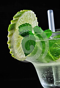 Alcohol drink, cocktail with mint, lemon, strows, isolated black