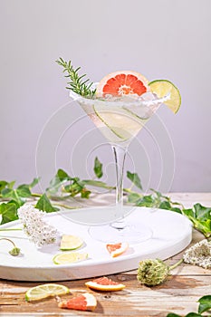 Alcohol drink, gin tonic cocktail with grapefruit, cucumber, rosemary, lime, refreshing, cold drinks with ice on a rustic table.