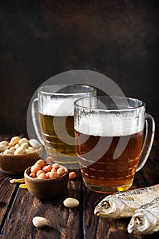 Alcohol drinkpint of lager and pint of stout, craft beer. Two Glass of Beer with foam and snacks on a wooden rustic background.