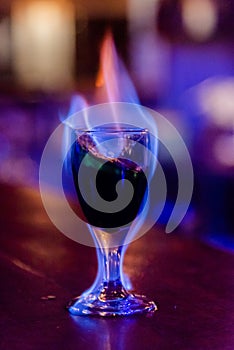 Alcohol exotic cocktail burning with fire on the bar table