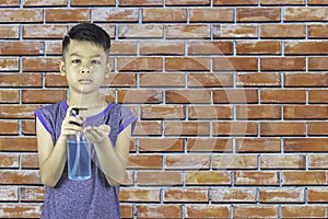 Alcohol gel bottles In the hands of asian boy background brick wall
