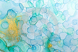 Alcohol ink green and gold abstract background. Drops watercolor texture.