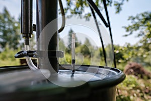 Alcohol mashine in a village courtyard, on a blurred background. Preparation of an intoxicating beverage. Close-up.