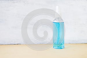 Alcohol in plastic bottle spray with space on white wood background