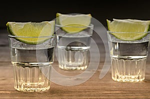 Alcohol shots with a lime on wooden background/Alcohol shots with a lime on wooden background. selective focus