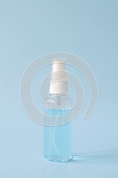 Alcohol spray in a bottle on blue background for clean hand and protect coronavirus or covid-19