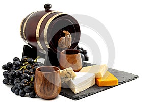 Alcohol, winery snack,  picnic and alcoholic beverages concept with wood barrel of red wine, mix cheese and grapes isolated on