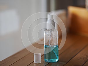 Alcoholic 70 percent in clear bottle on the wooden desk for spray washing clean dirty kill to prevent germs protect colona virus,