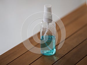 Alcoholic 70 percent in clear bottle on the wooden desk for spray washing clean dirty kill to prevent germs protect colona virus,