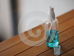 Alcoholic 70 percent in clear bottle on the wooden desk for spray washing clean dirty kill to prevent germs protect colona virus,