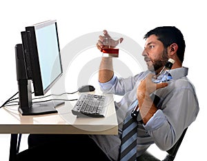 Alcoholic business man drinking whiskey sitting drunk at office with computer