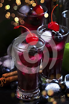 Alcoholic cocktail with blueberry, cinnamon and lime, named berry me, black table, selective focus