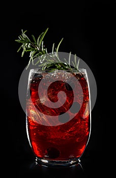 Alcoholic cocktail Bramble cocktail with blackberries and crashed ice on black background.