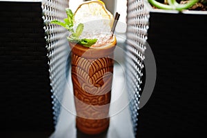 Alcoholic cocktail with mint in originally voodoo earthen glass