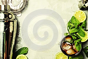 Alcoholic cocktail with rum, cola, ice and mint, bar tools, drink background, top view