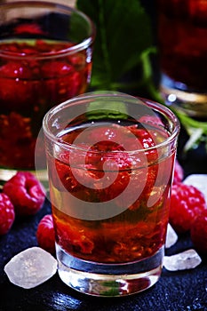 Alcoholic cocktail with strong alcohol, syrup and fresh raspberr