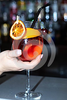 Alcoholic cocktail in a transparent glass on a thin leg.