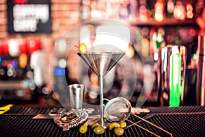 Alcoholic drink on bar counter. Dry martini with ice and olives, served cold in restaurant, bar or pub.