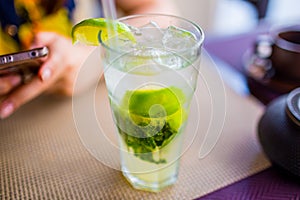 Alcoholic drink concept. Mojito with ice and lime in glass close up