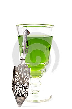 Alcoholic drink, creative stimulant and bohemian lifestyle concept theme with glass of green absinthe and stainless steel spoon