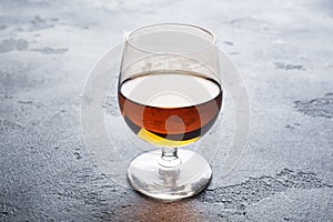 Alcoholic drink in a glass of Cognac brandy. Dark concrete background. Copy space