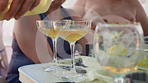 Alcoholic drink is poured into champange glasses. Alcohol before dinner