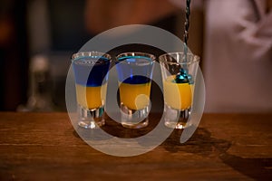 Alcoholic drinks in glass piles on a wooden table.