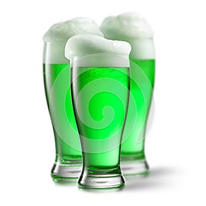 Alcoholic green beer in the glasses on a white.