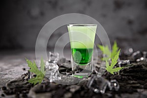 Alcoholic Green mexican cocktail in shot glass shooters. Cool drink from strong vodka, whiskey and sweet liqueurs.