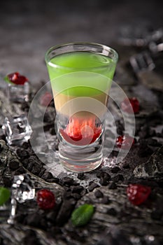 Alcoholic Hiroshima cocktail in shot glass. Cool drink from strong absinthe, whiskey and sweet liqueurs.