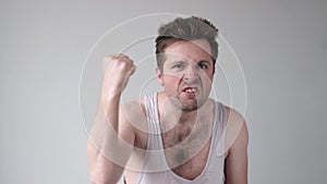 Alcoholic man showing his fist and shouting with angry expression