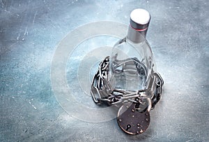 Alcoholism, alcohol addiction concept with alcohol drink bottle and chain with lock