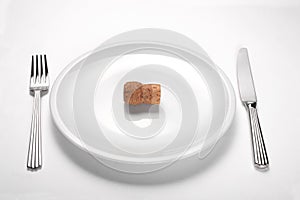 Alcoholism concept: champagne cork on an empty white dish on white background