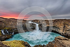 Aldeyjarfoss waterfall in Iceland at sunrise with golden clouds in the sky. Amazing landscape in beautiful tourist attraction. Won