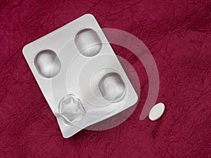 Alendronate sodium pack, nonhormonal medication for treating postmenopausal osteoporosis in women. On red cloth.