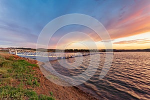 Alentejo travel destination in Portugal, Europe. Colorful landscape with pier on the Alqueva lake at sunset. Boat dock is a touris