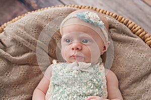 Alert Baby Girl Lying in a Wicker Basket