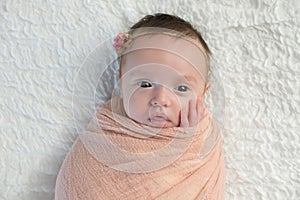 Alert Baby Girl Swaddled in a Light Peach Wrap