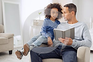 Alert father and daughter reading a book