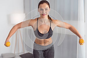 Alert woman using hand weights while exercising