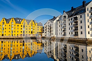 Alesund, Norway - April 14, 2018: Colorful architecture of Alesund reflected in the water of the harbour, Norway