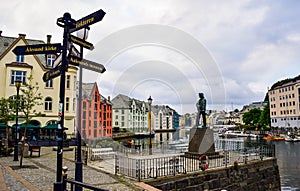 Monument to the young fisherman. Cityscape of the beautiful neo-Gothic architecture of Alesund city. Norway