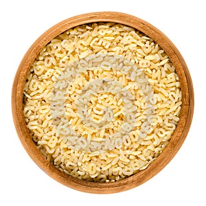 Alfabeto, alphabet pasta in wooden bowl over white photo