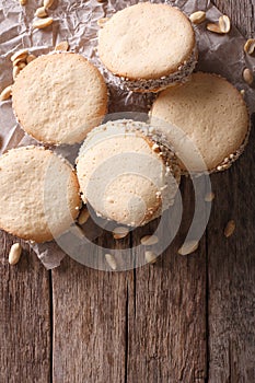 Alfajores cookies on paper on the table. Vertical top view