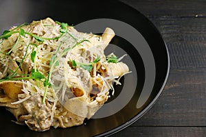 Alfredo pasta with beef, chease and microgreen closeup on wooden table photo