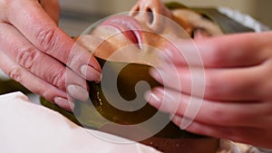 Algae face mask. Woman on seaweed wrap at a spa salon. Woman is having a procedure in cosmetology cabinet