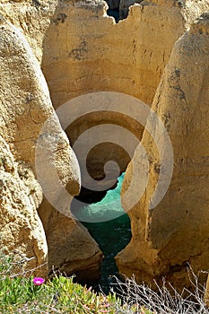 Algarve coastline with turquoise ocean water between eroding cliffs