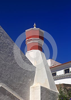 Algarve, Portugal. Typical huge chimney and whitewashed walls against a blue sky.