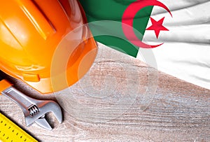 Algeria flag with different construction tools on wood background, with copy space for text