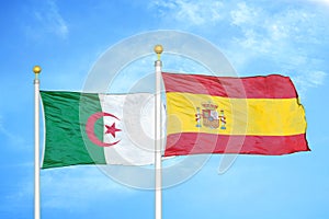 Algeria and Spain two flags on flagpoles and blue sky photo